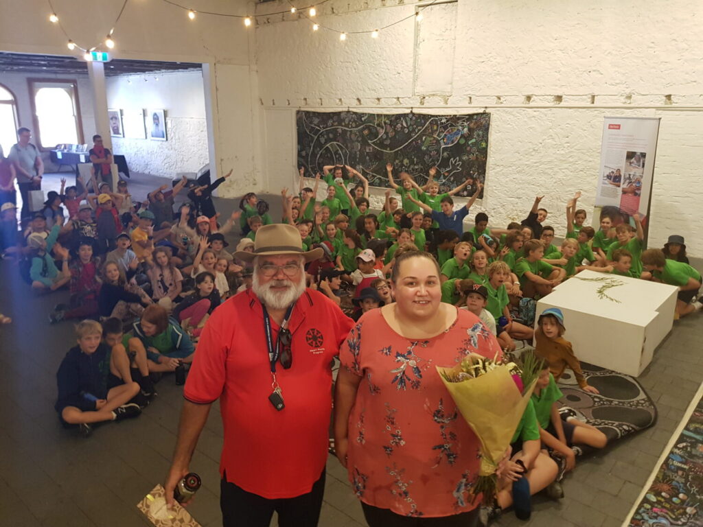 Two Noongar presenters standing in front of school students