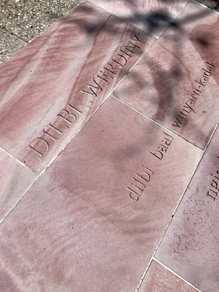 Poem engraved into pink sandstone pavement