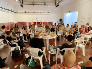 Group of Indigenous speakers sitting in a circle with the audience sitting around them